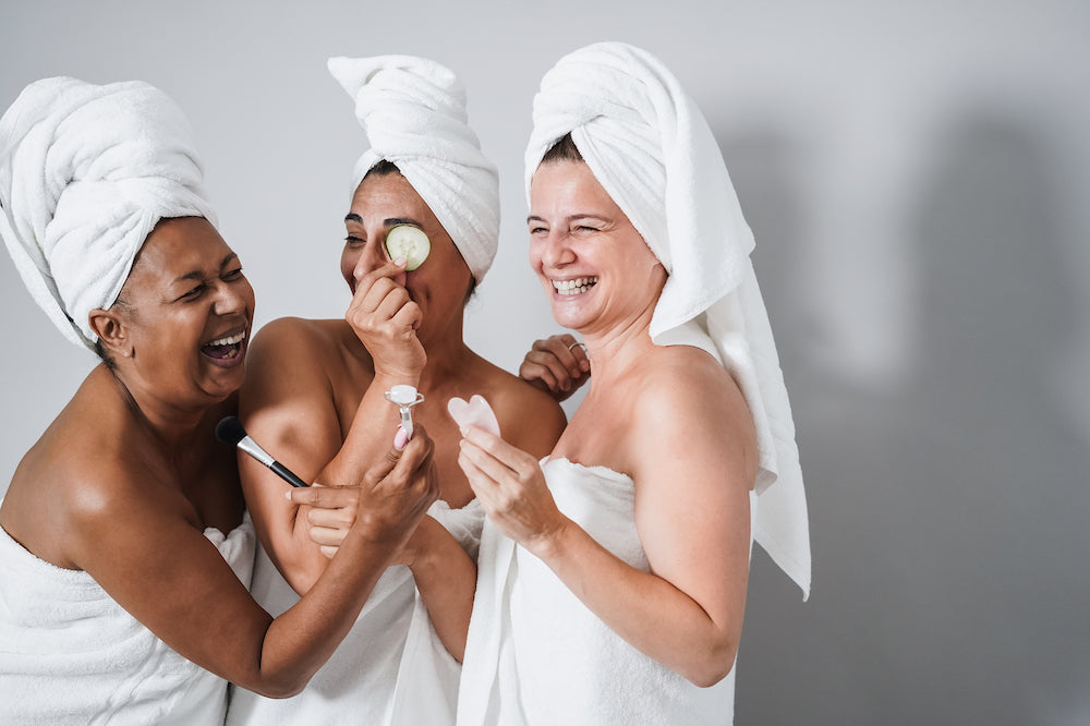 Multigenerational women having fun using skin care products